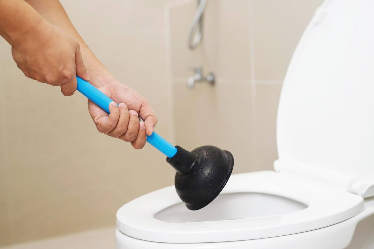 serviceman repairing toilet with hand plunger clogged toilet 109549 4223