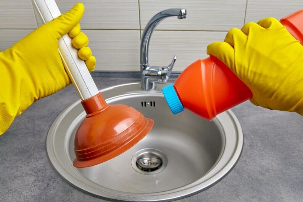 hands yellow rubber gloves hold plunger pipe cleaner 327813 1437